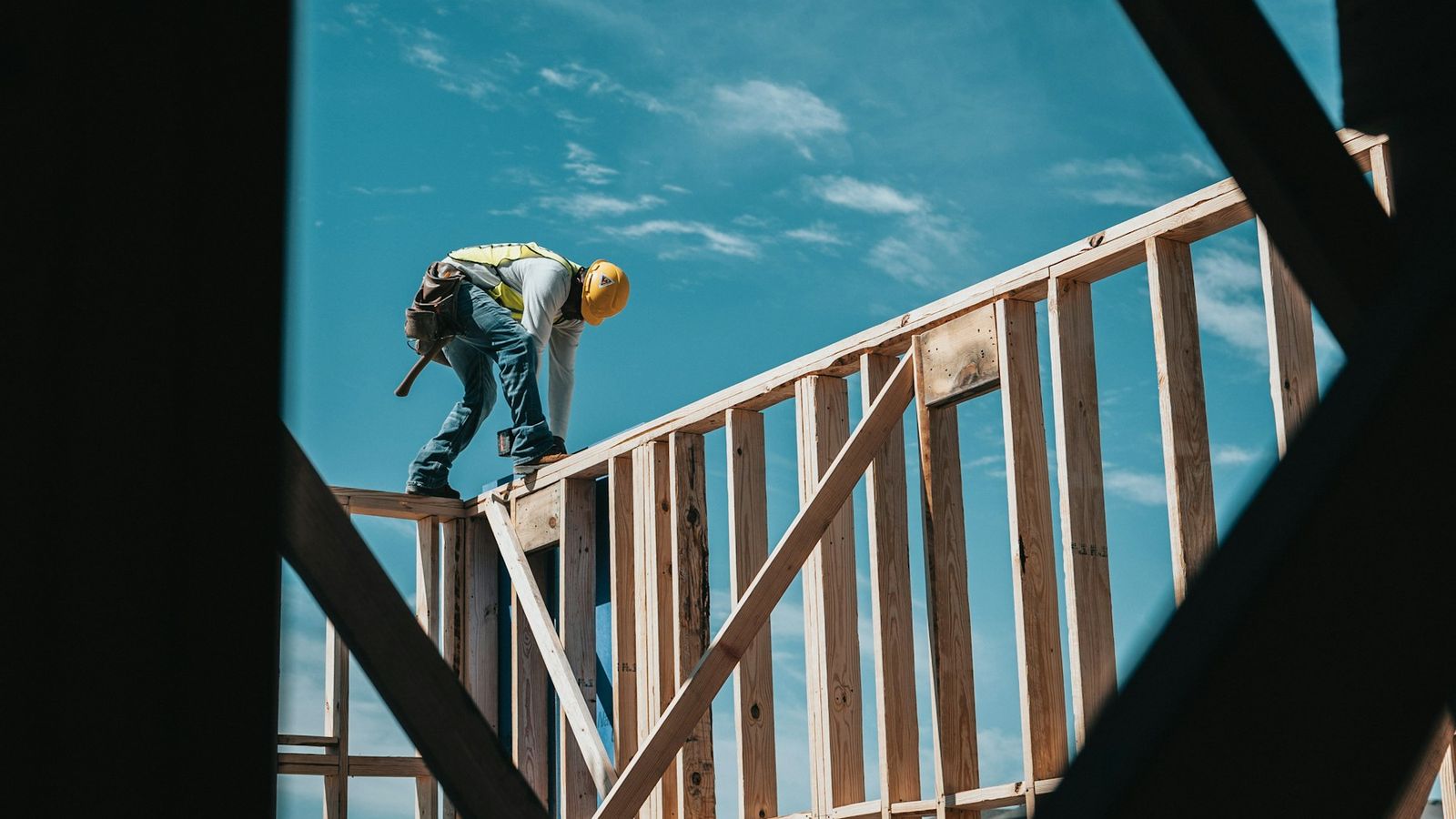 Construction worker in a hard hat on a timber building frame